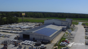 Artisun Solar project on Champion Precast building next to silos and vehicles.