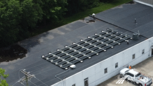 High-angle shot of the Keusch Glass building's solar array, showcasing its extensive coverage of the flat roof.
