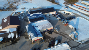 Aerial view of Martin's Auto Service in Illinois featuring a large commercial solar panel installation by Artisun Solar.