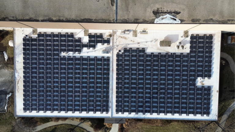 Overhead view of a flat-roof commercial solar array for Preston Refrigeration.