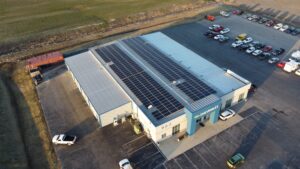 Commercial rooftop solar panel array installed by Artisun Solar at K & J Chevrolet in Carlyle, IL, utilizing federal and state tax credits to gain renewable energy and cost efficiency.