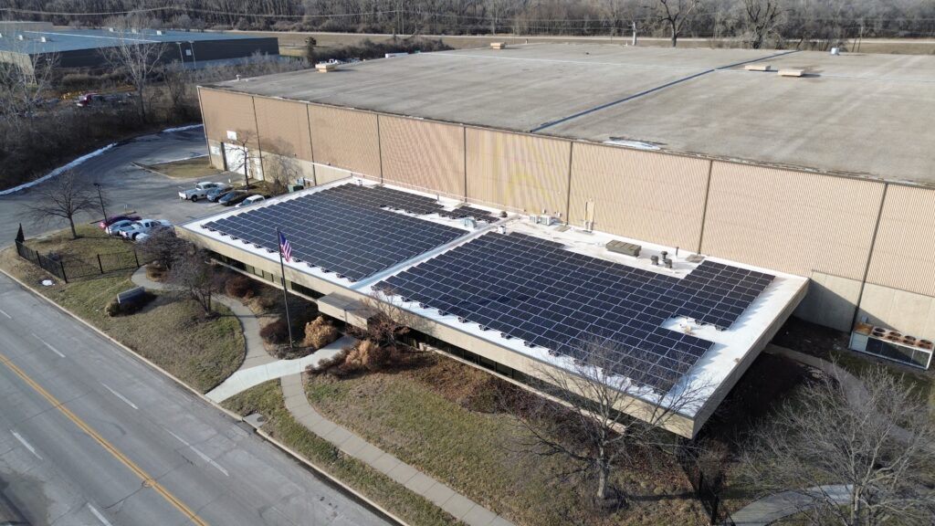 Wide aerial view of Preston Refrigeration's 105.1 kW (DC) rooftop solar installation, showing the full 365-panel layout.