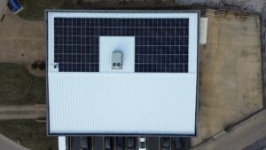 Top-down drone shot of a rooftop clean energy system designed to offset 1301.3 metric tons of CO₂ emissions.