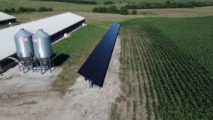 Aerial view of Judson Vos poultry barns and grain silos beside a 42.8 kW ground-mount solar array in Sully, IA.