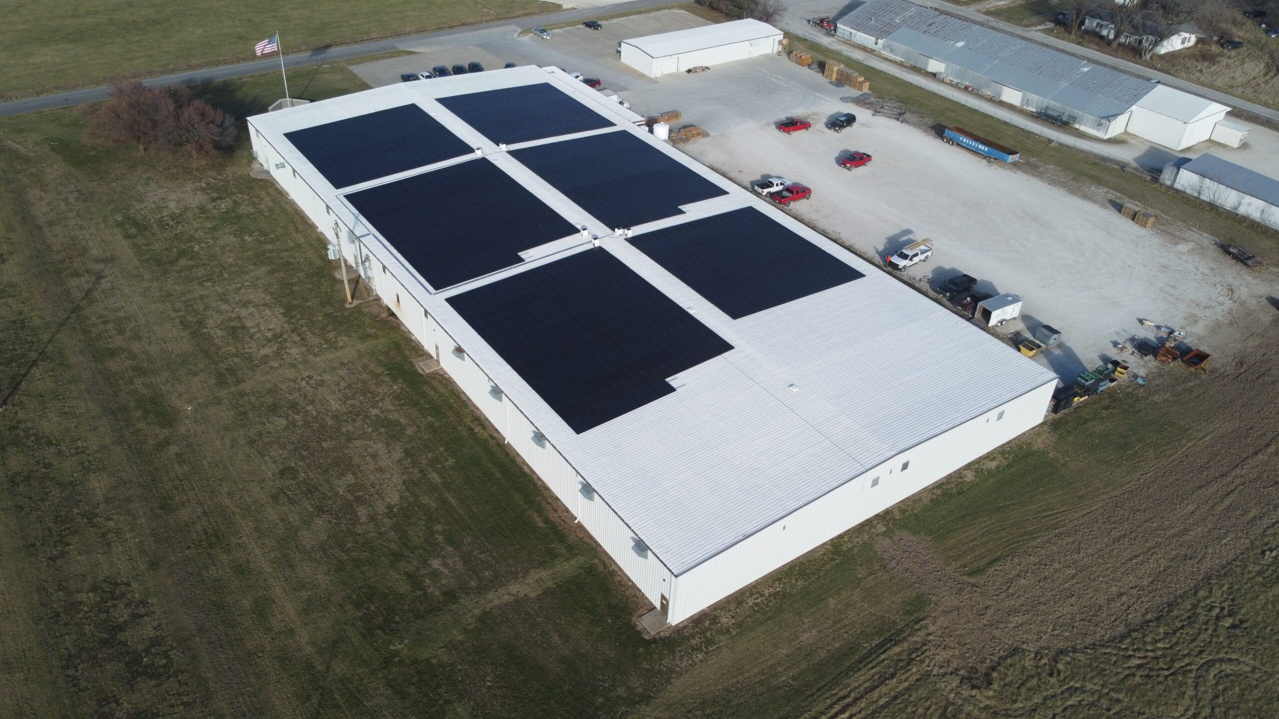 Aerial drone view of the 1,218-panel Artisun Solar installation at Mack Hils Metal Fabrication in Moberly, MO, projected to offset 85.82% of the facility's total electricity consumption.