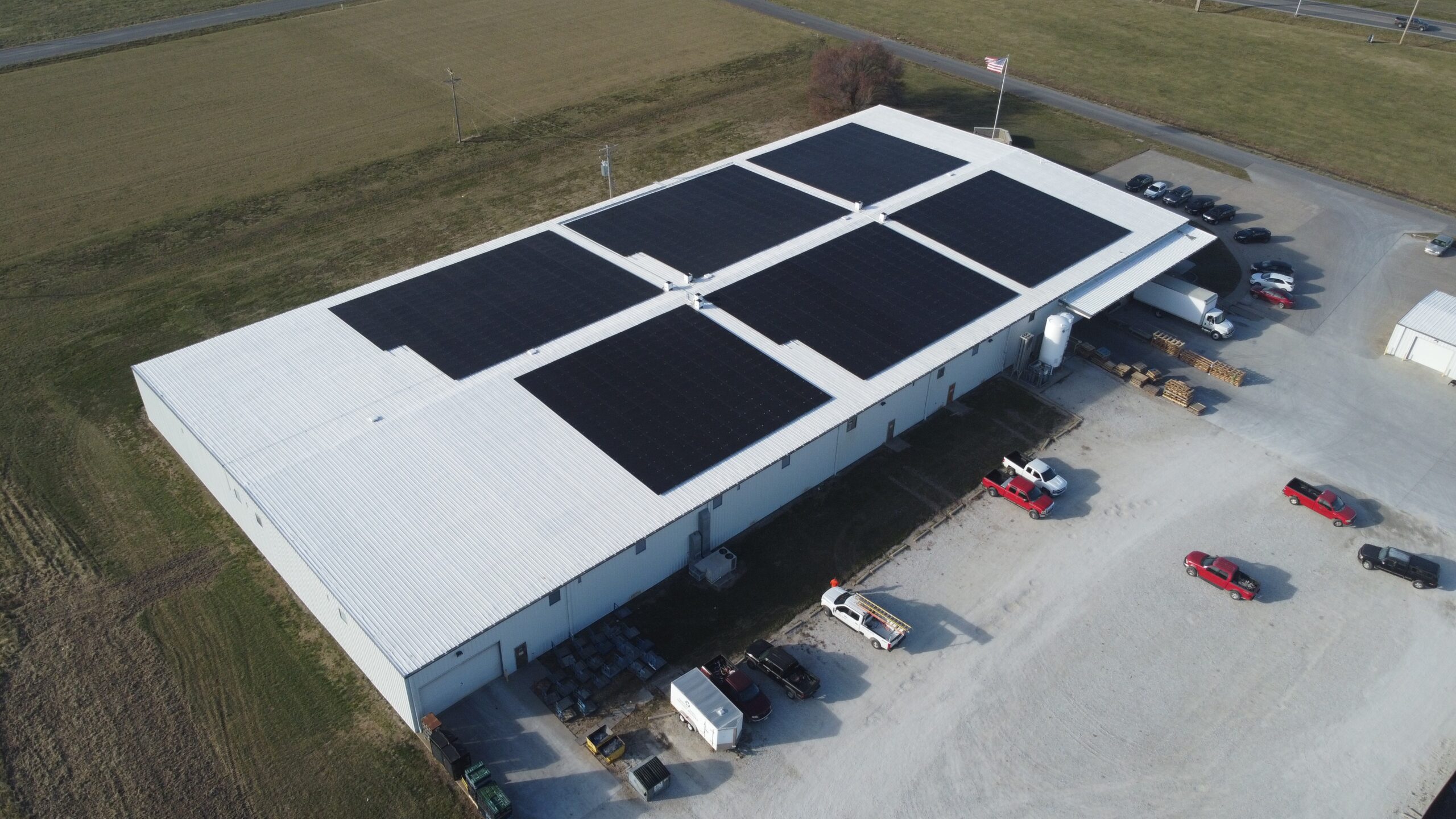 Broad aerial photograph of the Artisun Solar rooftop system at Mack Hils Metal Fabrication in Moberly, MO, projected to offset 12,702.5 metric tons of CO₂ emissions over its operational life.