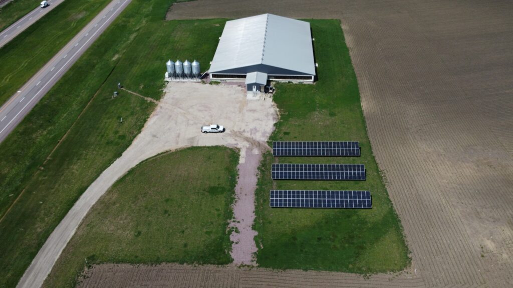 Aerial view of Tass Pork solar arrays offsetting 1,406.4 metric tons of CO₂ emissions in Ashton, IA.