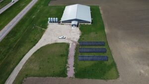 Aerial view of Tass Pork solar arrays offsetting 1,406.4 metric tons of CO₂ emissions in Ashton, IA.