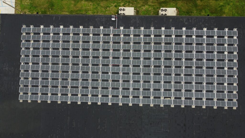 Top-down aerial view of the Ultimate Air rooftop solar installation in Scott City, MO, showing the 210-panel grid array engineered to achieve a 1.2-year payback period.