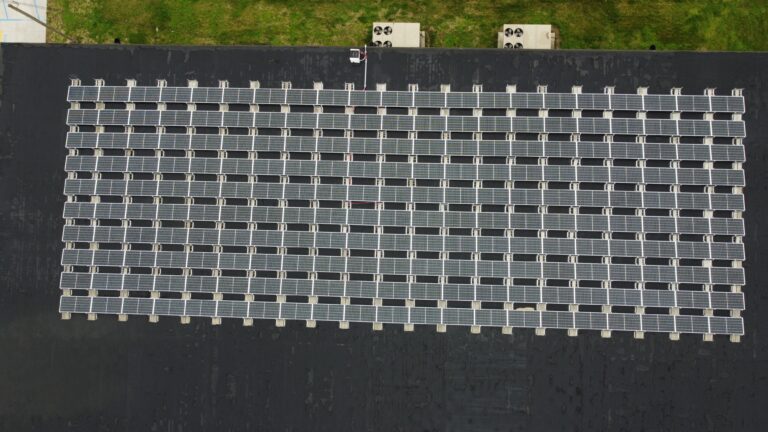 Top-down aerial view of the Ultimate Air rooftop solar installation in Scott City, MO, showing the 210-panel grid array engineered to achieve a 1.2-year payback period.