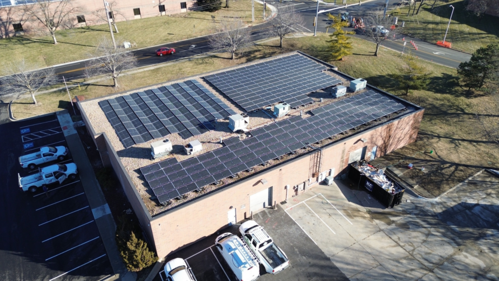 Wide aerial shot of the commercial roof at Artisun Solar showing ballasted and east-west solar arrays.