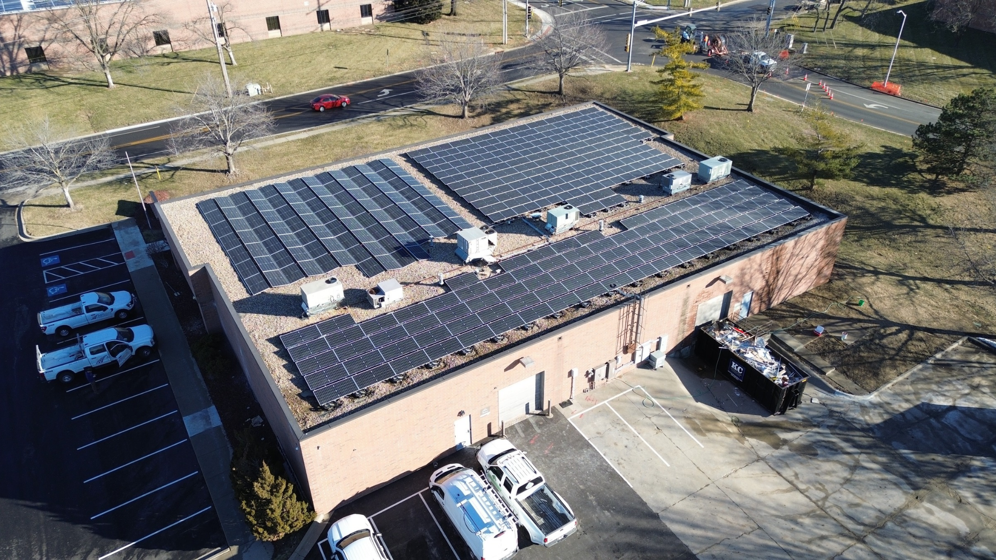 Wide aerial shot of the commercial roof at Artisun Solar showing ballasted and east-west solar arrays.